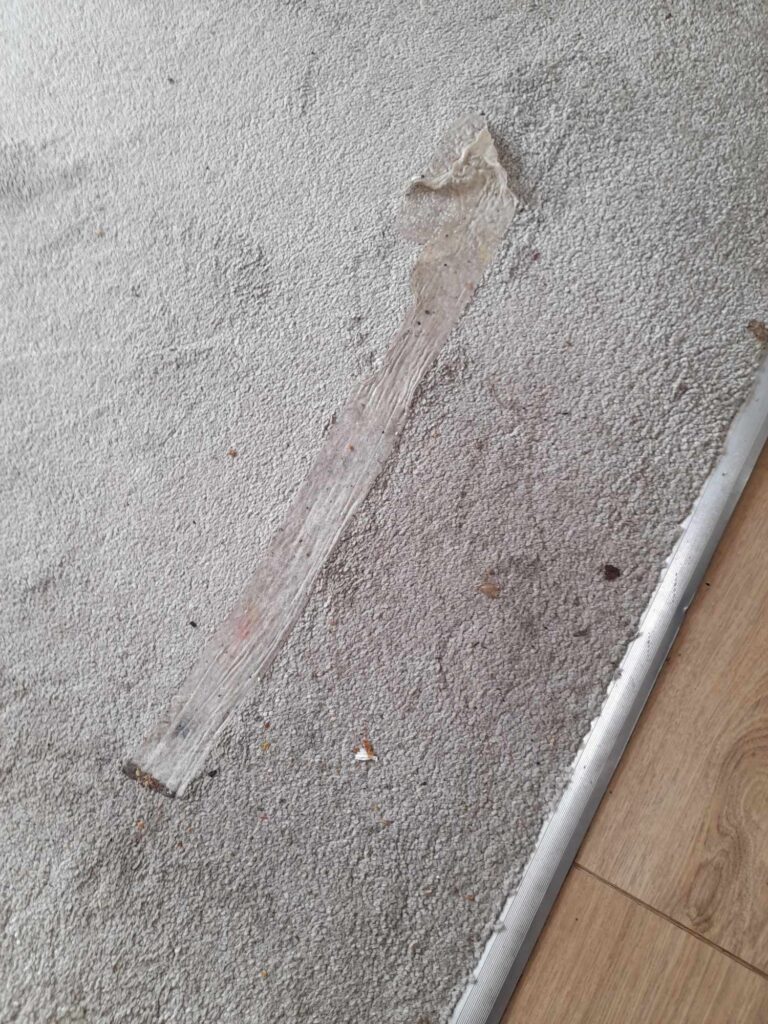 carpet with double sided tape which previously held down a rug sitting over the top
